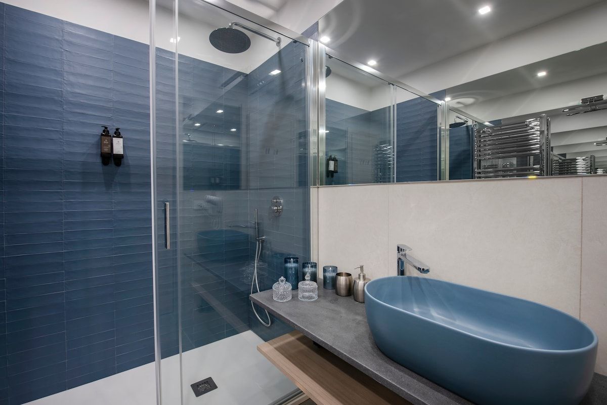 Blue-tiled bathroom with walk-in shower