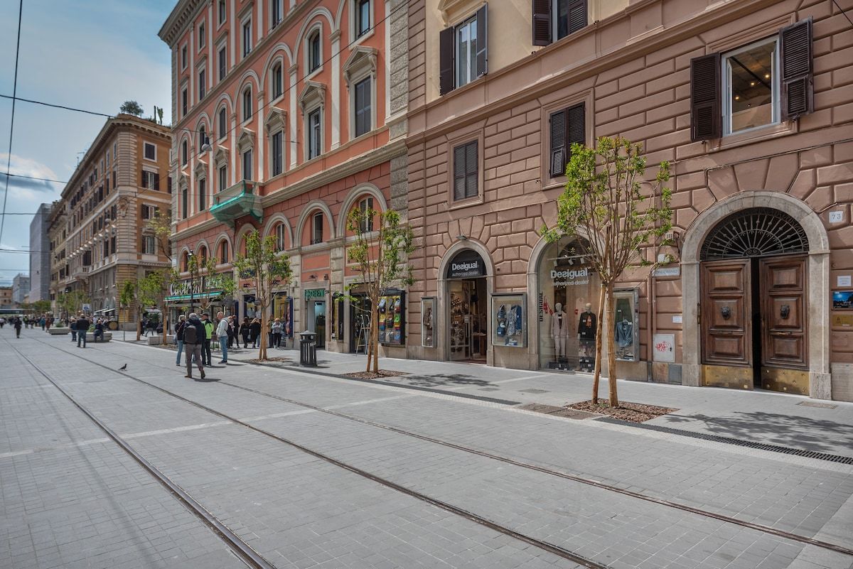 Pedestrian Via Ottaviano, with pink palazzi and tram tracks